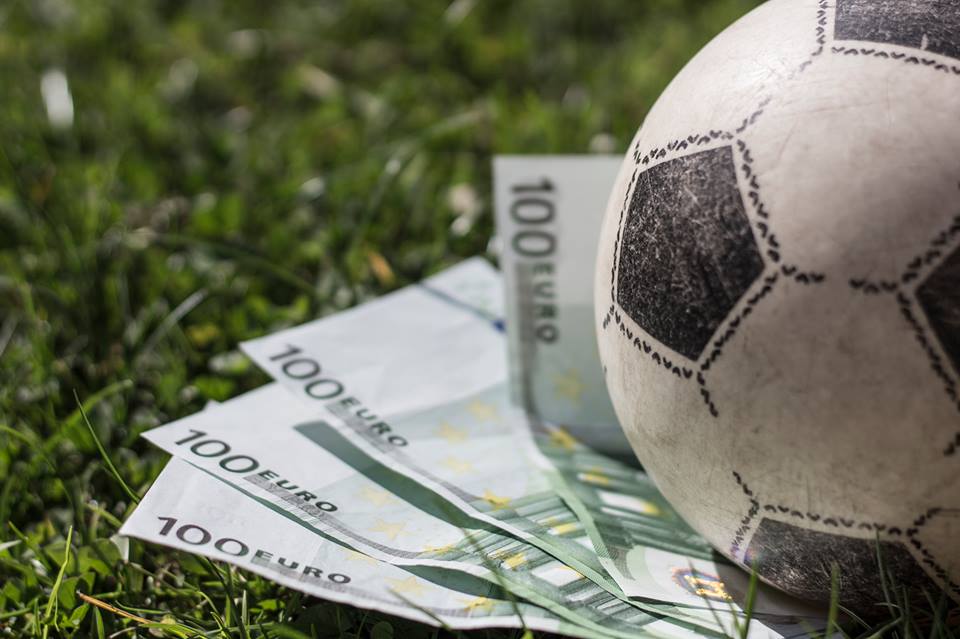 100-Euro-Scheine liegen unter einem Fußball.