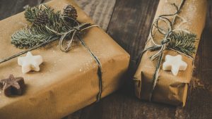 Geschenke in weihnachtlicher Verpackung liegen auf einem Holztisch