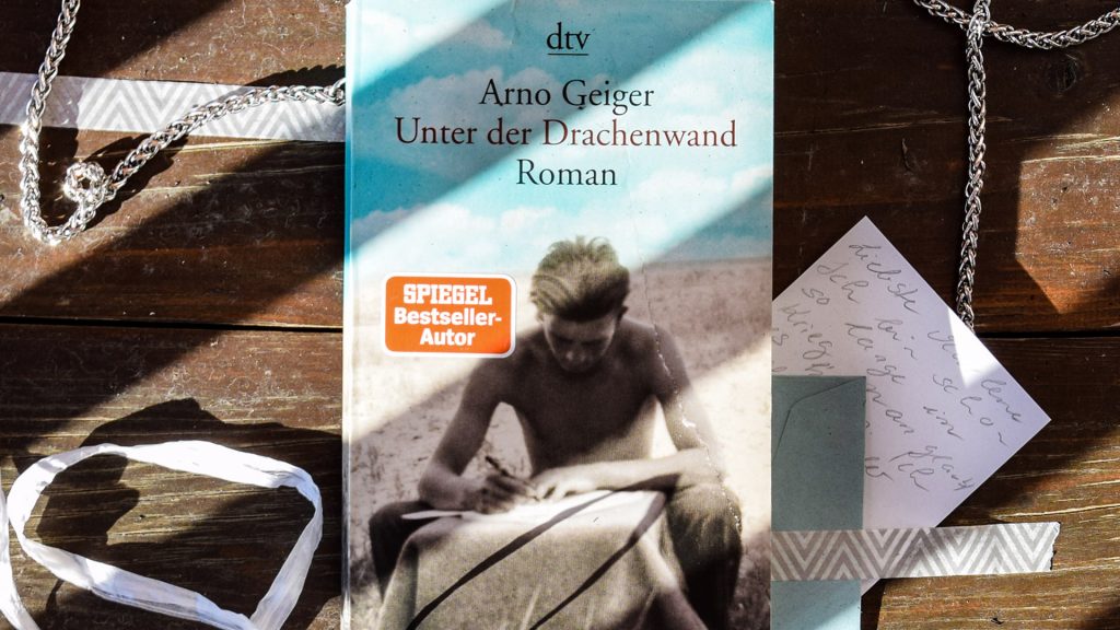 Das Buch Unter der Drachenwand auf einem Tisch liegend