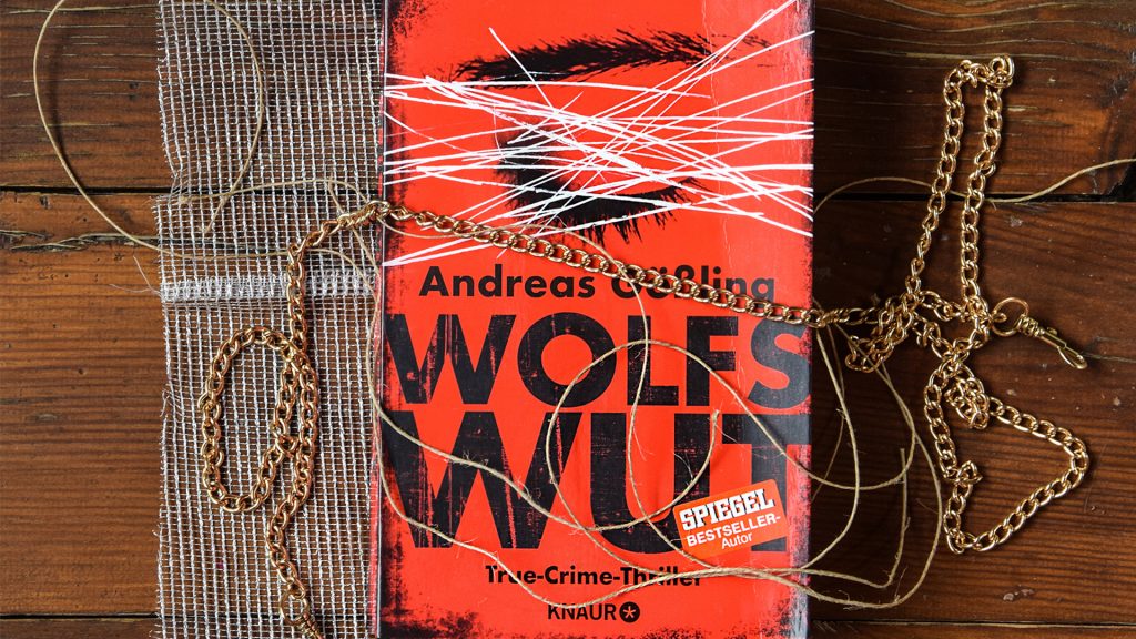Das Buch "Wolfswut" auf einem Holztisch liegend