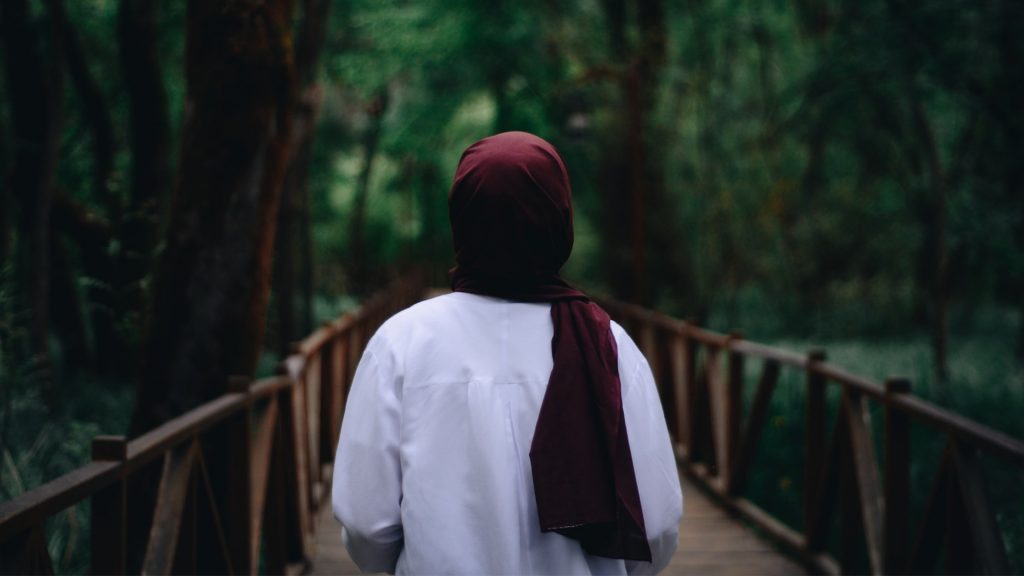 Frau mit Hijab im Wald, Foto von hinten