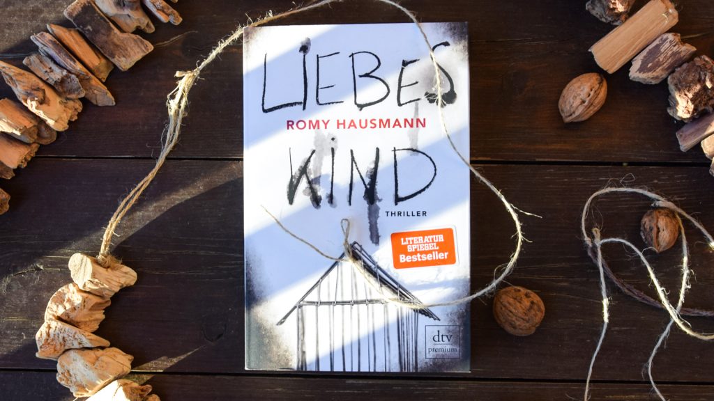 Das Buch "Liebes Kind" mit Deko auf einem Hoztisch