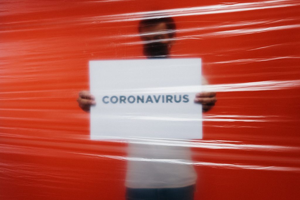 Mann hält Schild "Coronavirus"