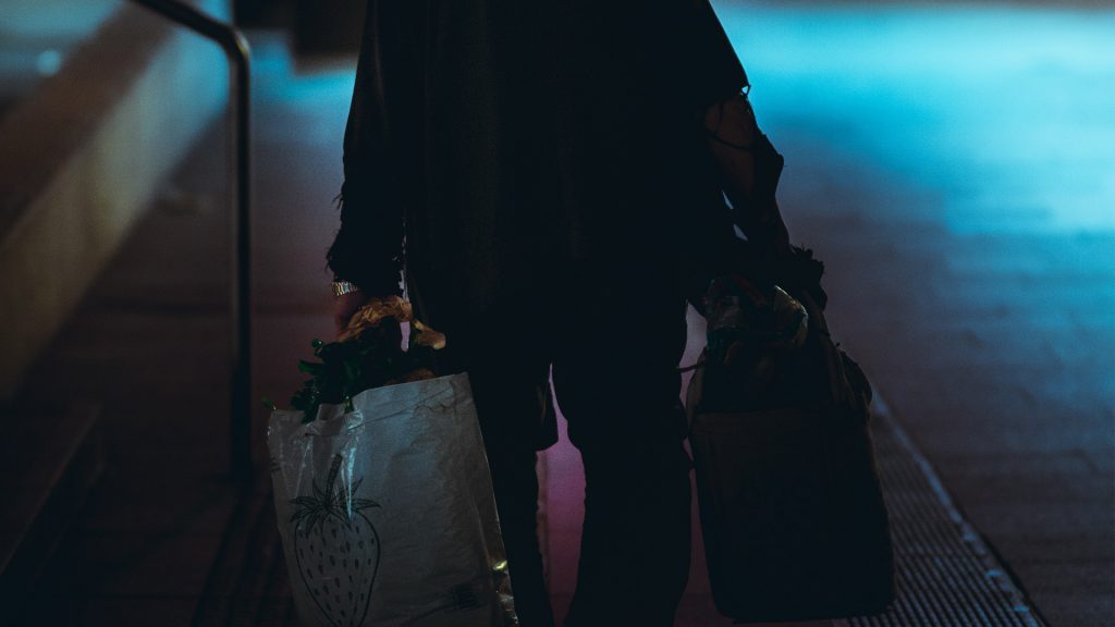 Mensch trägt zwei Taschen, Dunkelheit