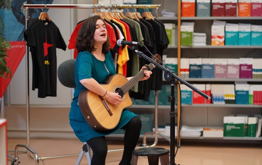 Frau spielt Gitarre und singt