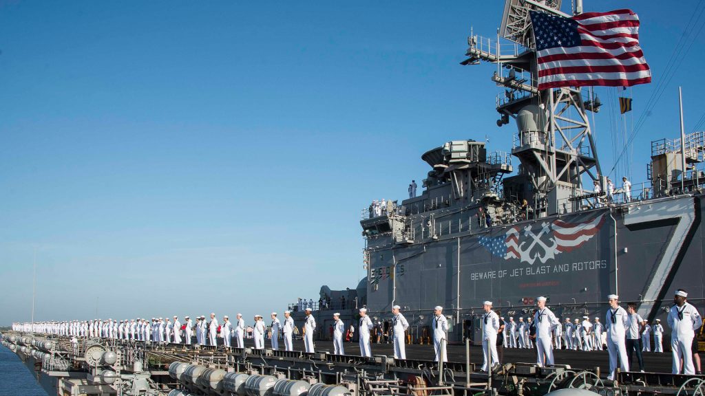 Marine-Soladten des US-Armee stehen in einer Linie am Rand eines langen Schiffes