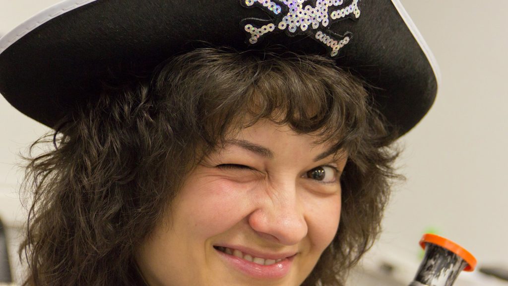 Junge Frau mit Piratenhut zwinkert