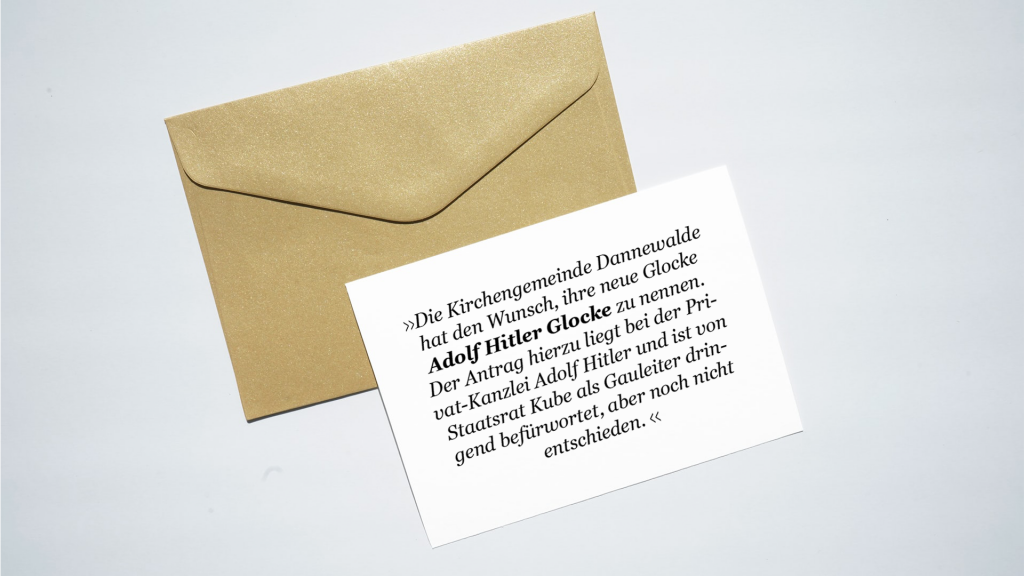 Weißer, beschrifteter Zettel liegt auf braunem Briefumschlag.
