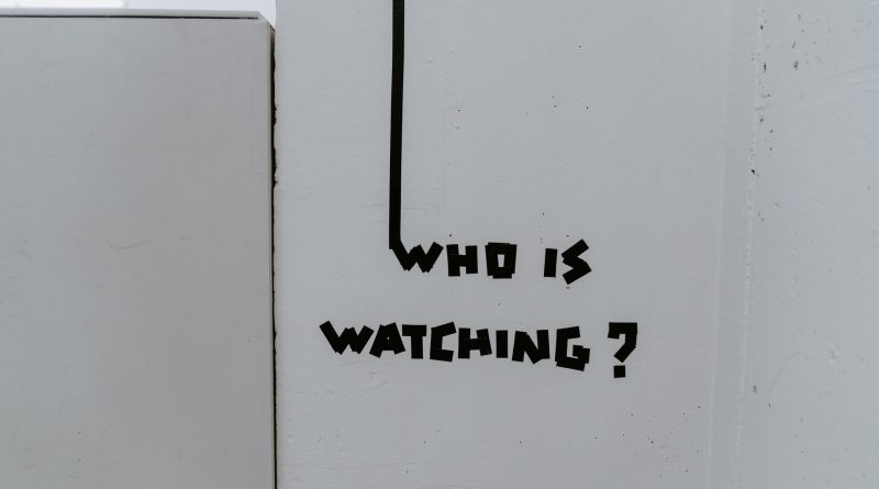 Schrift "Who is watchign" auf weißem Hintergrund