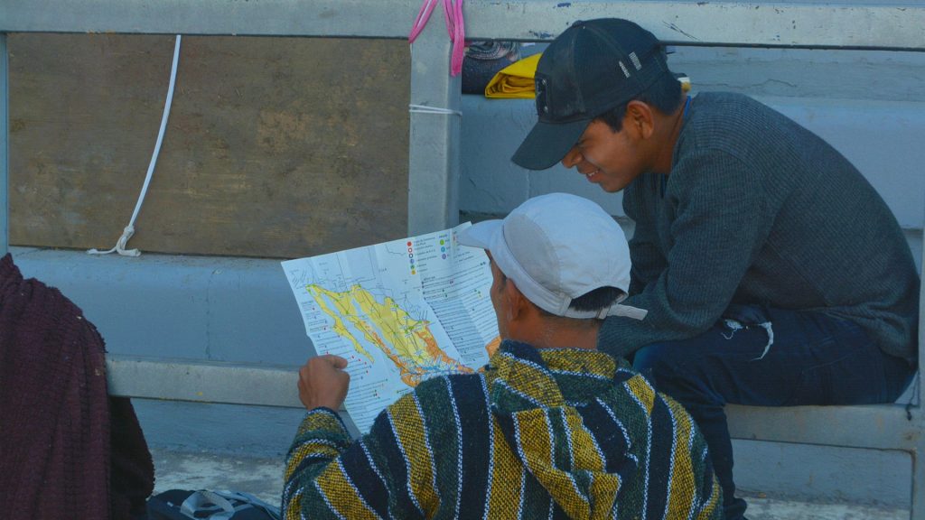 Zwei Migranten lesen eine Landkarte