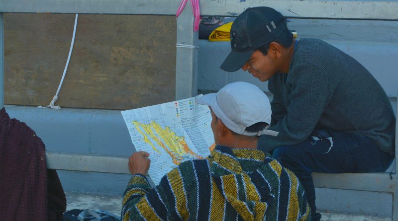 Zwei Migranten lesen eine Landkarte