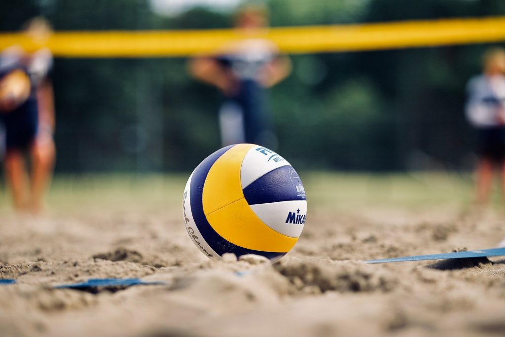 Ein Volleyball liegt im Sand