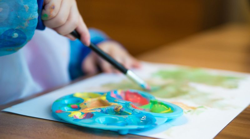Kind malt mit Wasserfarben