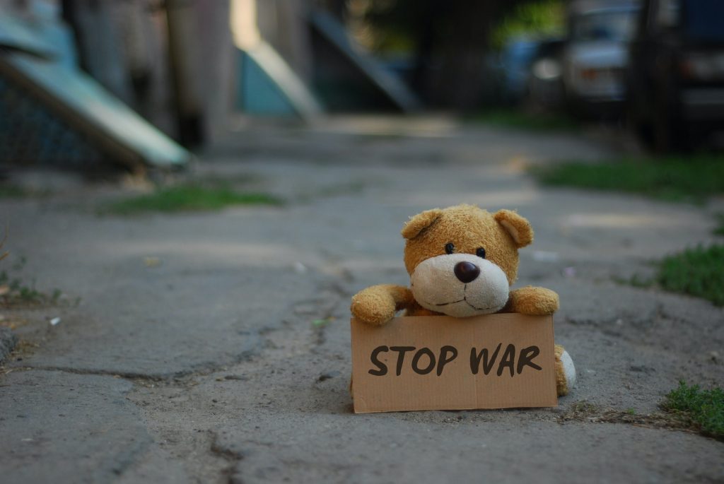 Teddybär hält Schild mit Aufschrift "Stop War"