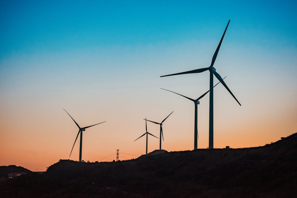 Silhouetten von Windrädern bei Sonnenuntergang