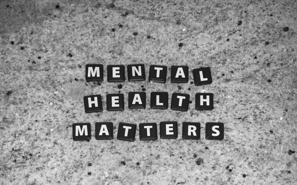 Schwarze Scrabble-Buchstaben auf grauem Boden: Mental Health Matters