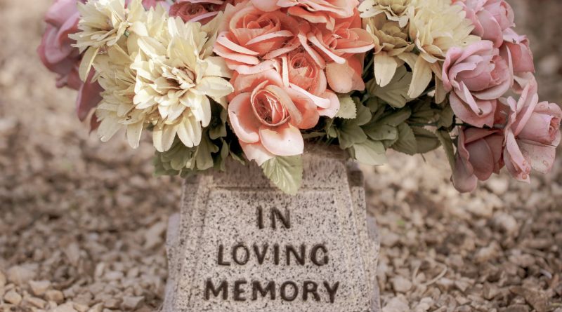 Blumen auf einem Stein mit der Aufschrift: In Loving Memory