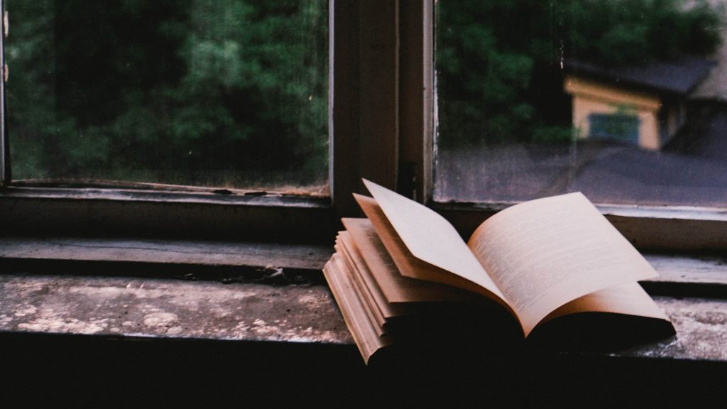 Offenes Buch liegt auf einer Fensterbank