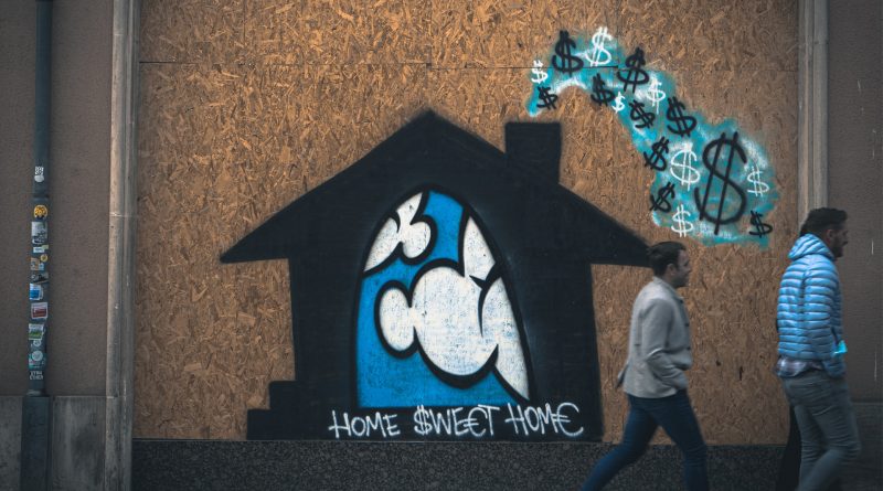 Graffiti: HOME $WE€T HOM€ auf einem schwarzen Haus , aus dessen Schronstein Dollarzeichen kommen