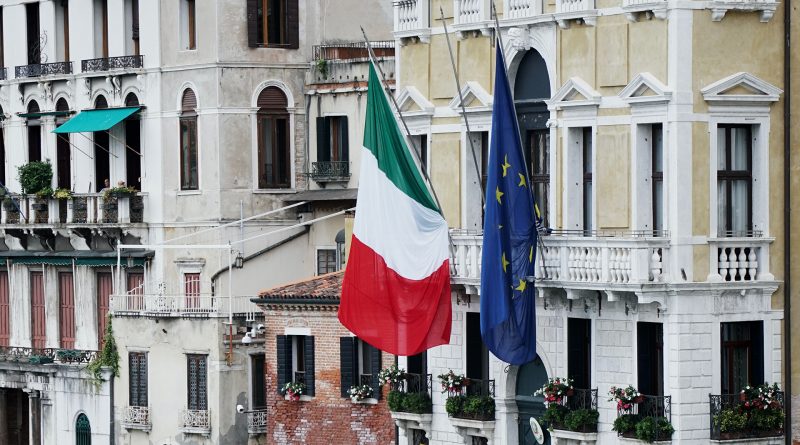 Flaggen von Italien und EU hängen schlapp an einem Gebäude