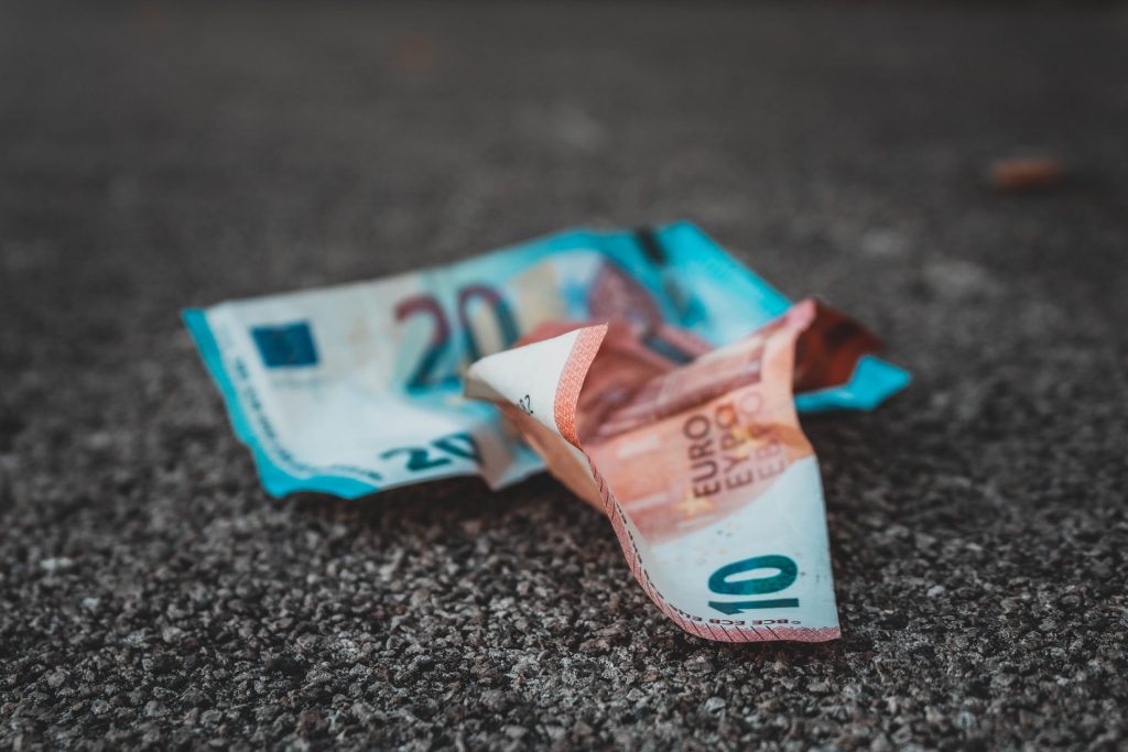 Zerknittertes Geld am Asphaltboden