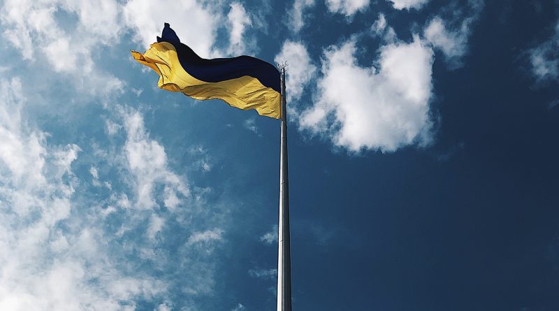 Ukrainische Flagge auf Fahnenmast vor blauem Himmel