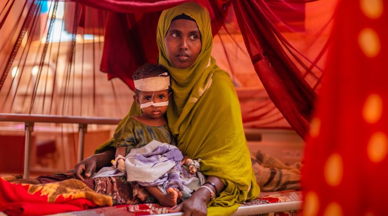 Frau mit organem Hijab kümmert sich um ihre unterernährten Sohn, der am Gode Hospital Stabilization Centre in Äthiopien behandelt wird.