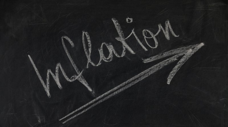 Das Wort Inflation mit Pfeil nach oben mit Kreide auf einer schwarzen Tafel geschrieben