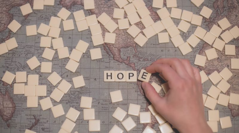 Das Wort Hope in Scrabbel-Buchstaben auf einer Weltkarte