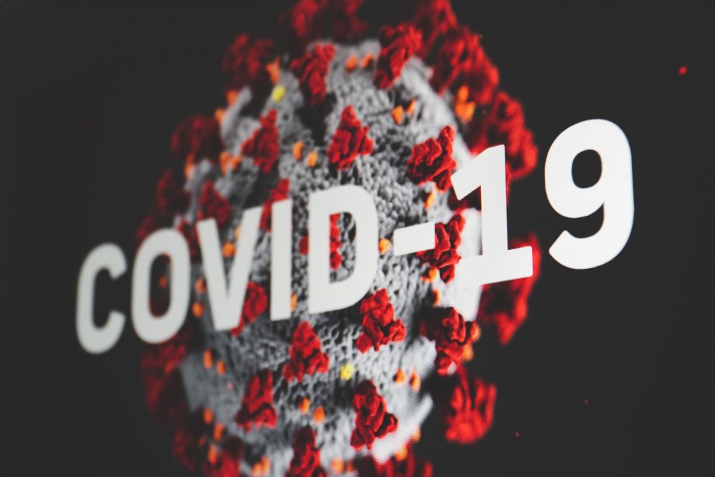 Darstellung des Corona-Virus, weißer Schriftzug "COVID-19"