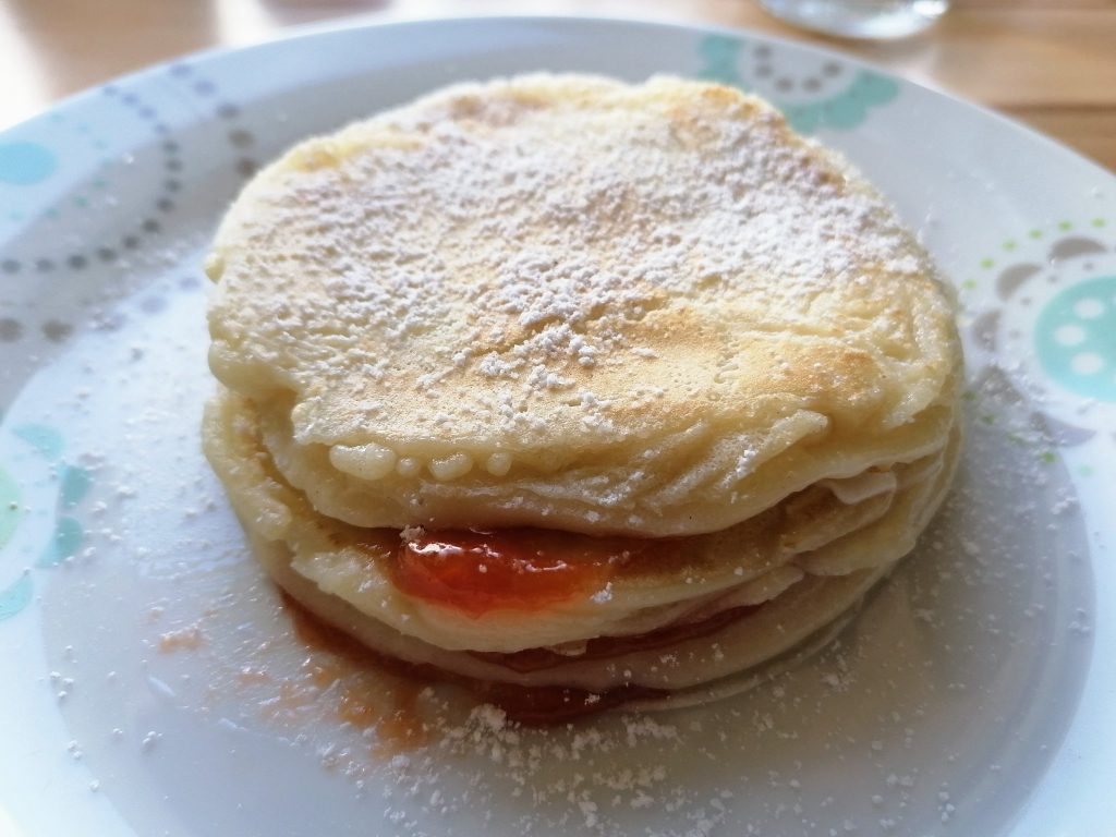 Pancakes mit Marmelade auf einem weißen Teller