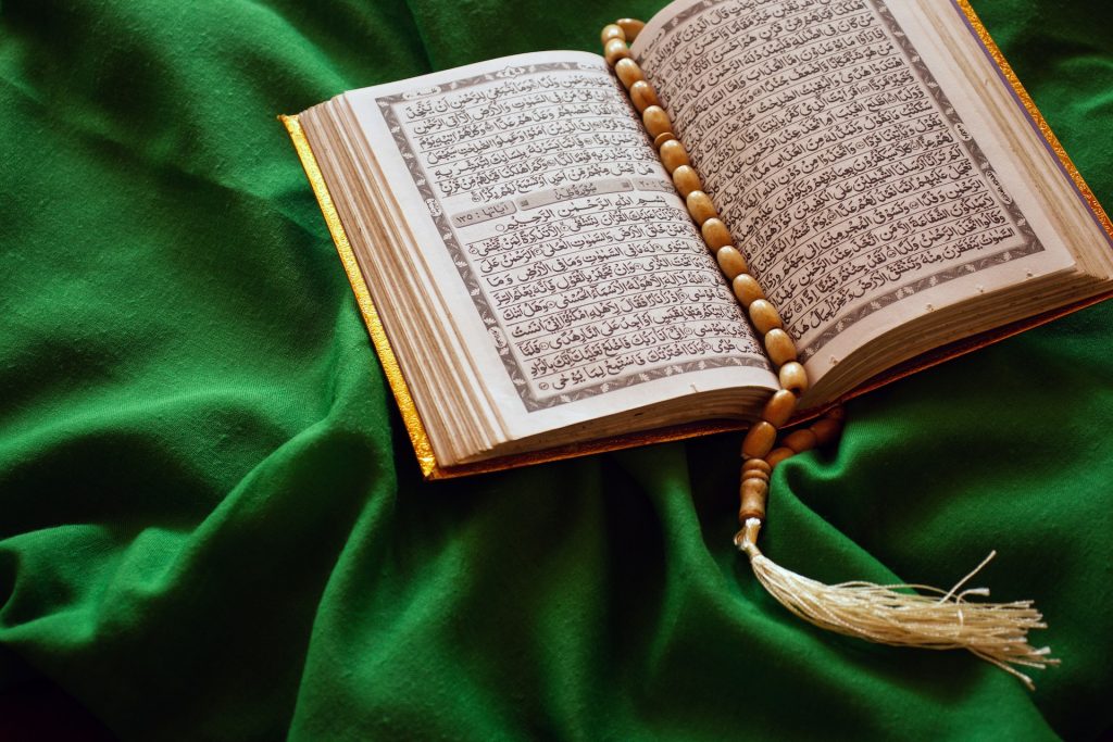 Offener Koran auf einem grünen Tuch