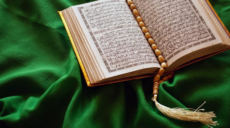 Offener Koran auf einem grünen Tuch