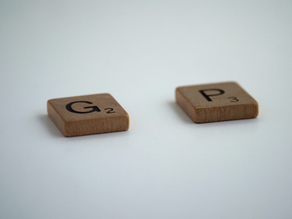 Zwei Scrabbel-Steine "G" und "P" liegen auf einer weißen Oberfläche, das fehlende A soll den Gap ausdrücken
