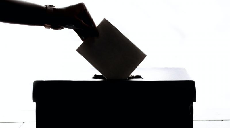 Kuvert wird in eine Wahlurne geworfen, schwarz-weiß, Silhouette