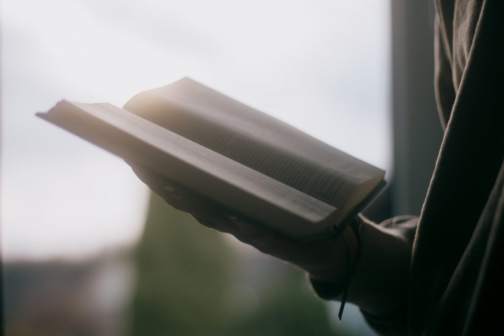 Person hält religiöse Schrift in den Händen