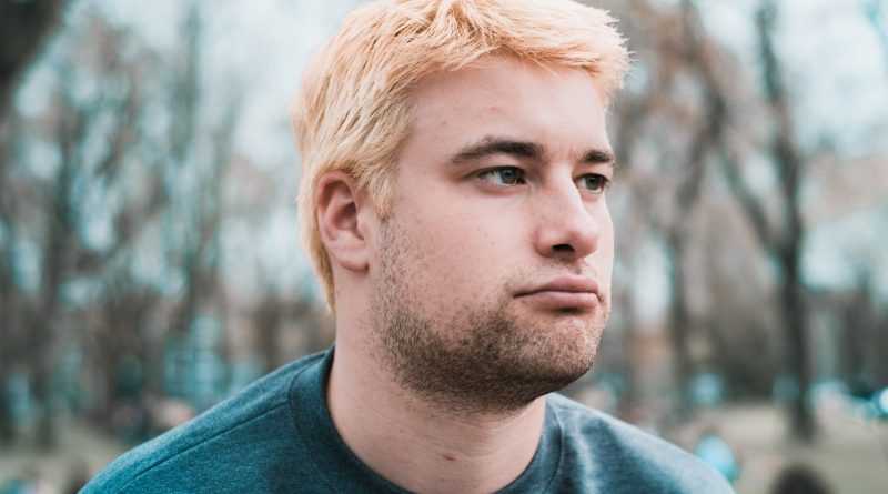 Portrait eines Mannes mit blonden Haaren und braunen Bartstoppeln, der ein unzufriedenes Gesicht macht