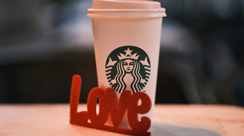 Starbucks-Becher, davor in rot das Wort LOVE
