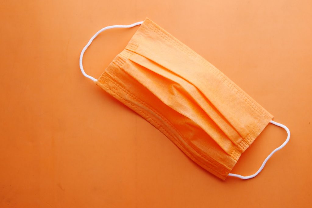 Orangene Maske auf orangenem Boden