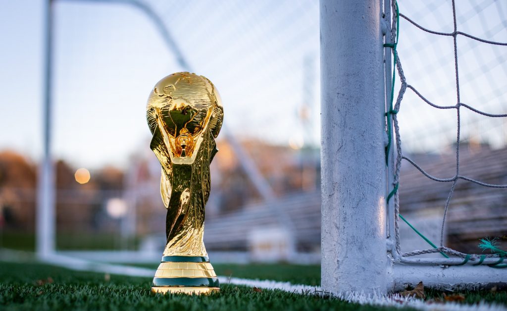 WM-Pokal vor einem Fußball-Tor auf dem Rasen