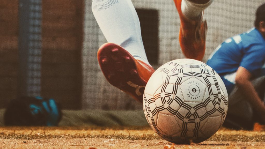 Nahaufnahme eines Balles, der von einem Spieler getreten wird
