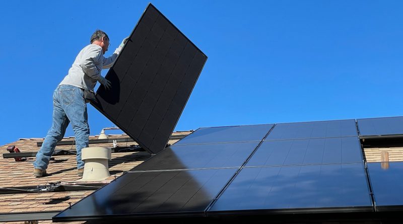 Arbeiter befestigt Solar-Panele auf einem Dach