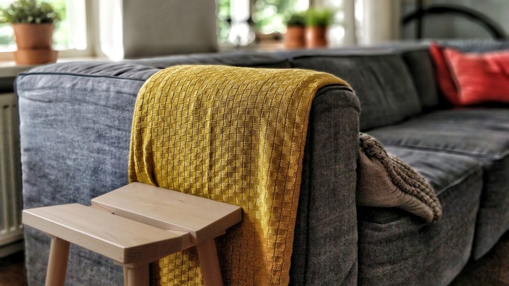 Eine Decke hängt über einer grauen Couch in einem Wohnzimmer