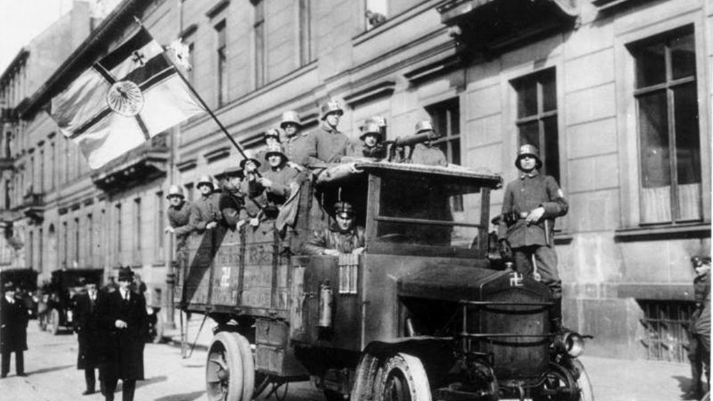 Schwarz-weiß Bild, Freikorps-Mitglieder auf einem Auto