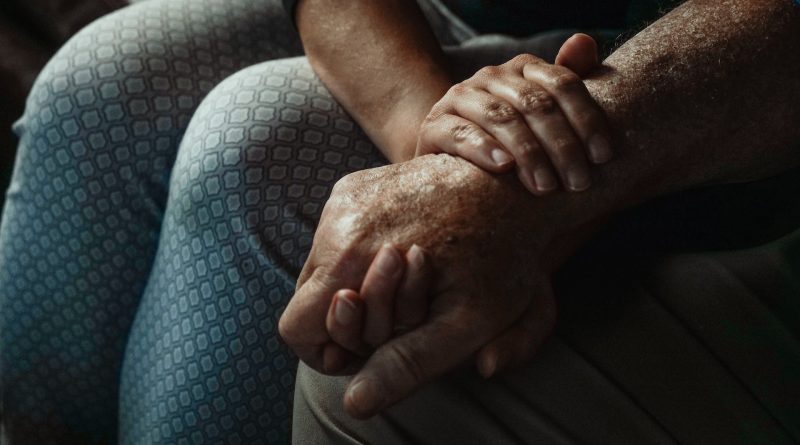Jüngere Person hält den Arm einer älteren Person