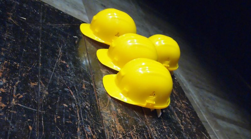 Gelbe Helme liegen auf einer dunklen Fläche