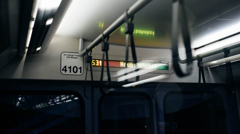 Eine Schnellbahn von innen, dunkel, leuchtende Anzeigetafel mit Schrift "Hauptbahnhof"