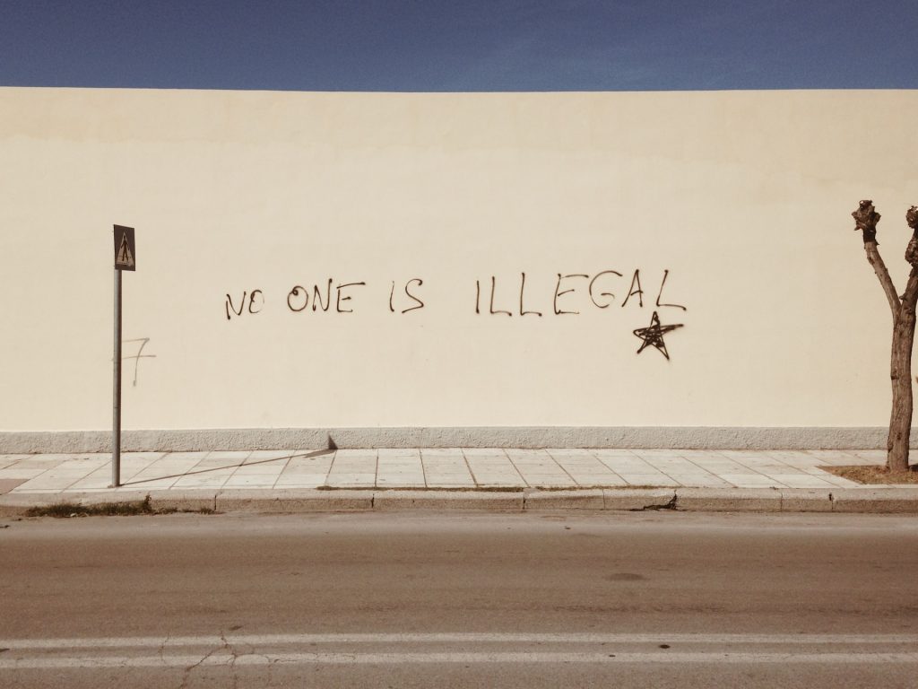 Weiße Mauer in Griechenland mit dem Spruch "No one is illegal"
