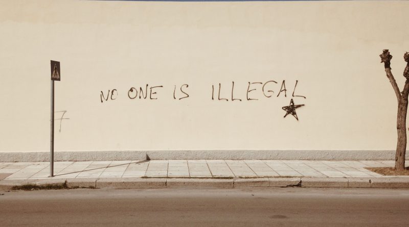 Weiße Mauer in Griechenland mit dem Spruch "No one is illegal"