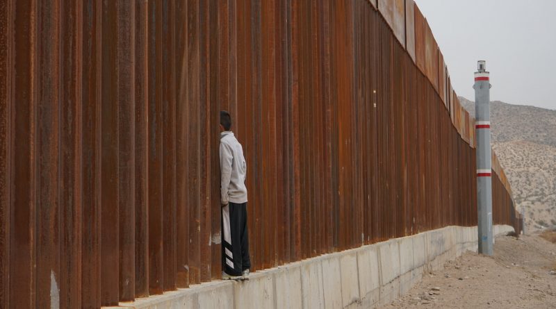 Flüchtlingskind steht an einem Grenzwall (Symbolbild)